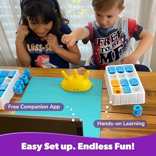 Two children playing with an interactive educational toy on a table.